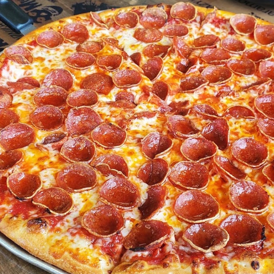 Close-up of a Santino's Pizzeria pepperoni pizza with melted cheese and a crispy crust.