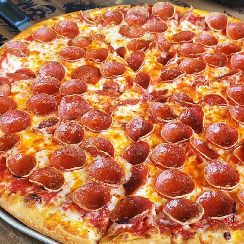 Close-up of a Santino's Pizzeria pepperoni pizza with melted cheese and a crispy crust.